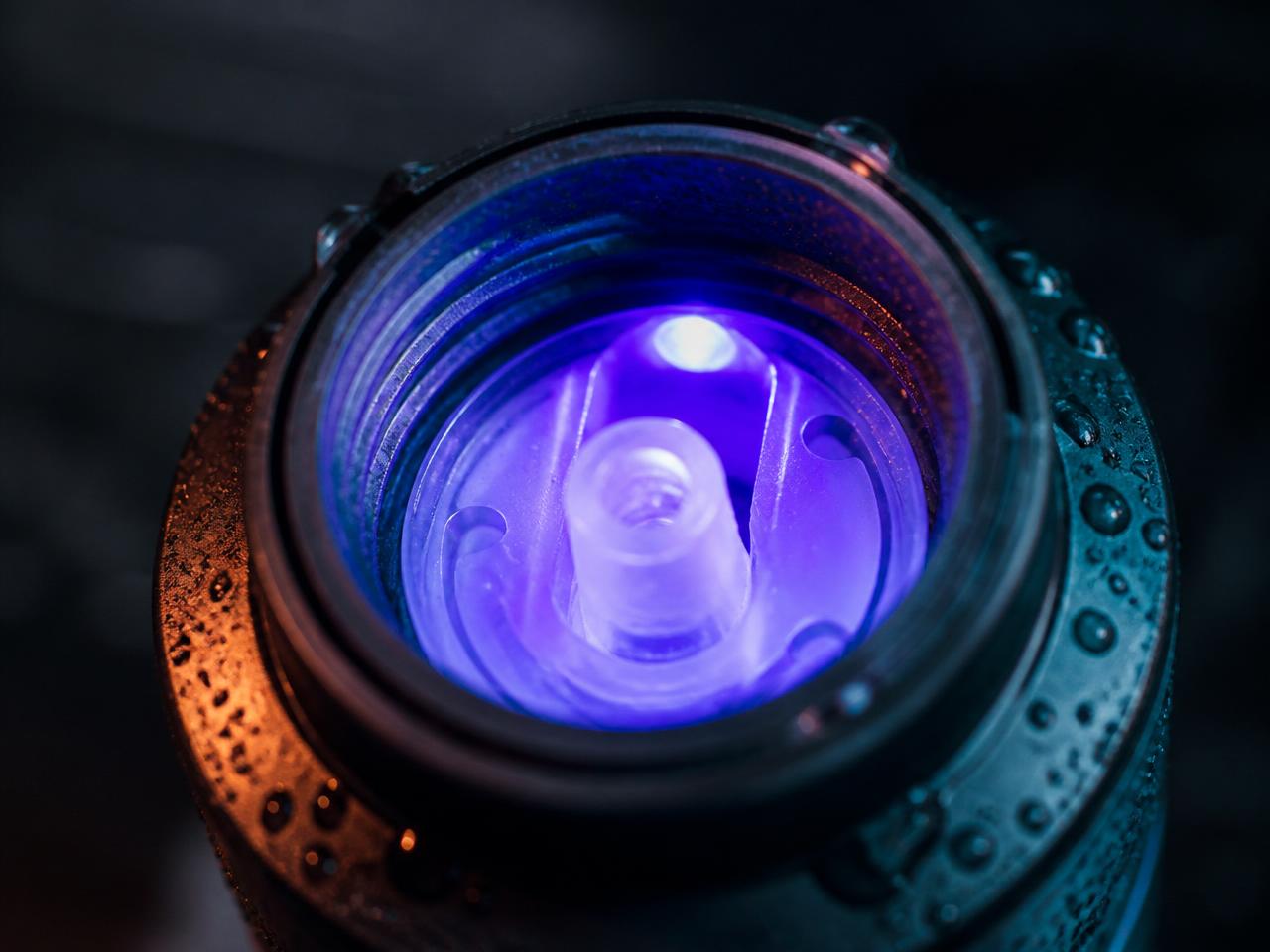 Close-up of the UltraV Bottle™ cap interior with violet UV-C light sanitising the mouthpiece
